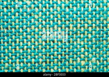 Fabric macro texture. knitted textile close up. woven background. woolen material. weaving green and yellow threads Stock Photo
