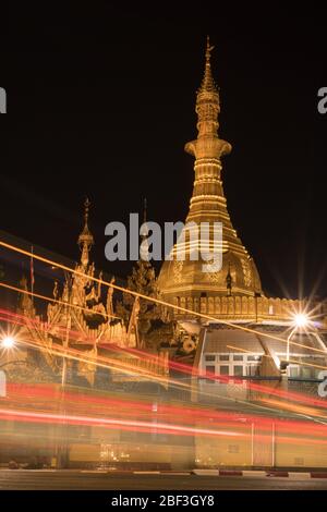 Traffic lights streak in front of the golden Sule Pagoda at night in Yangon, Myanmar Stock Photo