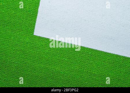 Green fabric texture with white painted place. knitted textile close up. woven background with copy space Stock Photo