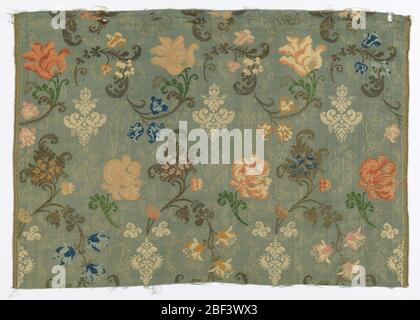 Textile. Straight repeat of curving floral forms in multiple colors and metallic thread on a blue-gray background. Stock Photo