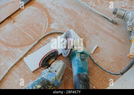tiler tool angle grinder and ceramic tile on a floor Stock Photo