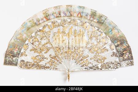 Pleated fan. Pleated fan. Narrow leaf with hand-colored lithograph on paper backed with painted parchment; sticks of carved and incised mother-of-pearl, washer and metal loop at the rivet. Stock Photo