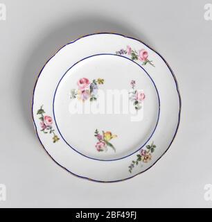 Plate. Circular, the rim scalloped and gilded. Cavetto and border with small polychrome floral sprays on white ground; the border with narrow blue stripes interrupted by short diagonal strokes of gold, in pairs. Stock Photo