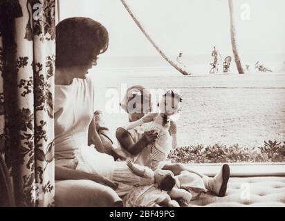 First Lady of the United States JACQUELINE KENNEDY daughter CAROLINE KENNEDY. President John F. KENNEDY can be seen in the distance on the beach. Stock Photo