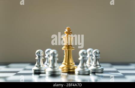 Golden King Chess is surrounded by silver chess, in conceptbusiness, triumph, success and competition. On board chess with a selective space copy focu Stock Photo