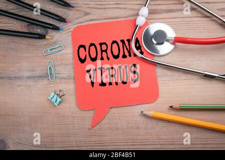 CORONAVIRUS. COVID-19 virus outbreak and pandemic concept. Red speech bubble and stethoscope on a wooden table Stock Photo