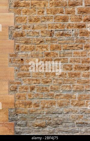 Texture background of a 19th Century light brown color natural stone wall with tuckpointing mortar joints Stock Photo