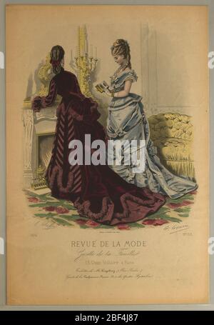 Plate No 153 in Fashion Review in the Family Gazette Revue de la Mode Gazette de la Famille. Fashion plate of two woman standing by a fireplace. Woman with back turned shows the back of her deep purpple velvet long sleeved jacket and skirt. A large bustle with draping fabric and train of dress. Stock Photo