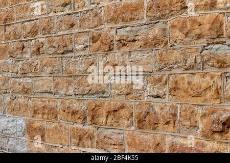 Texture background of a 19th Century light brown color natural stone wall with tuckpointing mortar joints Stock Photo