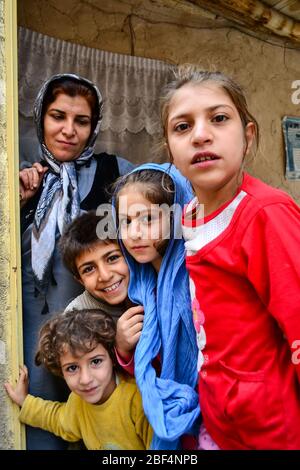 Palangan, Iranian Kurdistan - November 15, 2013: Group portrait of Kurdish family consistent of mother and children at the door of their home in Palangan old mountain village Stock Photo