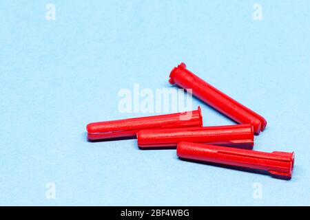 red plugs for concrete screw on blue background Stock Photo