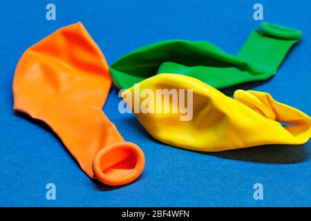 three balloons that are not inflated on blue background Stock Photo