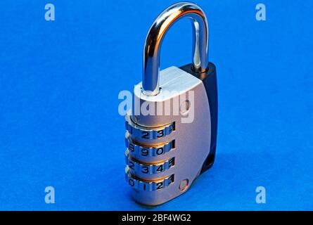 combination lock standing up on blue background Stock Photo
