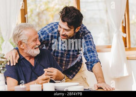 Young man love and care elder eating lunch meal for safe and stay at home happy smile family. Stock Photo