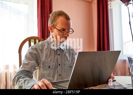 Young man working on laptop from home. Stock Photo