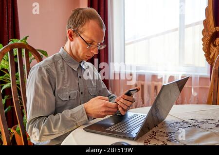 Senior businessman checking emails on their phone. Home office. Stock Photo