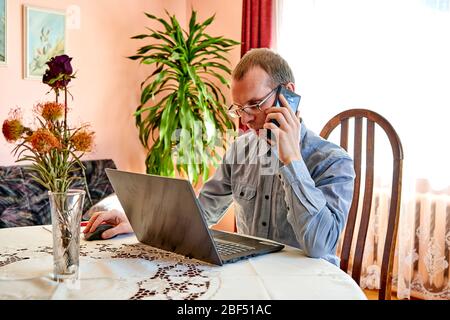 Man talking with phone and working in home office. Stock Photo