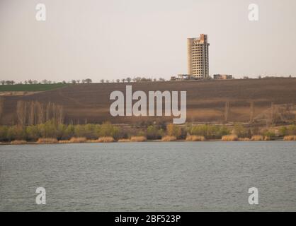 An old abandoned and unfinished building. in front of a lake Stock Photo