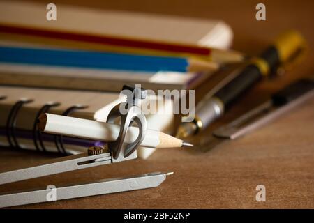 Compass for drawing and stationary on wooden table. Concept of architecture office or back to school. Closeup and copy space for text. Stock Photo