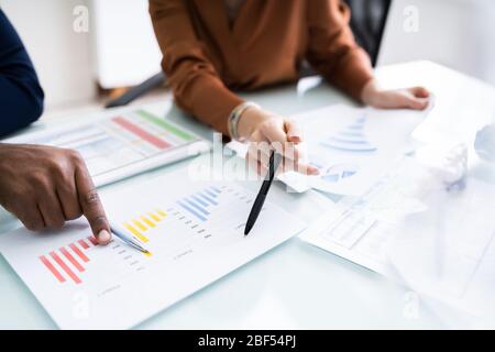 Cropped Image Of Businesswoman Writing On Graph At Desk In Office Stock Photo