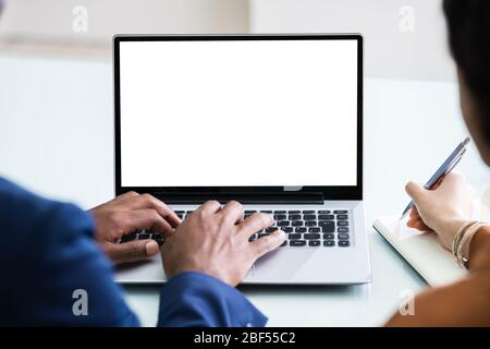 Two Businesspeople Working On Laptop With Empty Screen Stock Photo