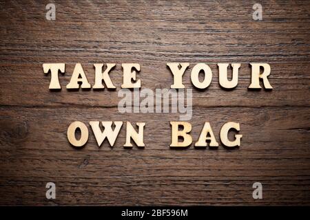 Take your own bag text on a wood table. Stock Photo