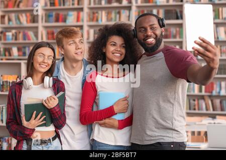 Young students taking selfie in library Stock Photo
