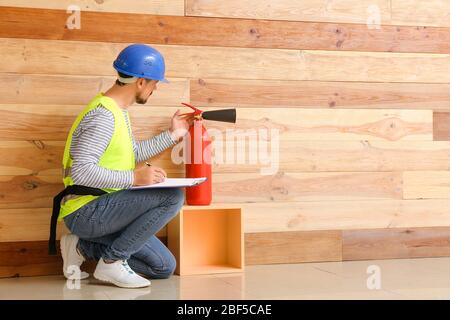 Fire safety specialist inspecting extinguisher Stock Photo