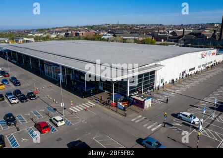 People queue 2 metres apart for a long distance outside of the Tesco extra store in Longton, Stoke on Trent, Social distancing, Covid 19, Coronavirus Stock Photo