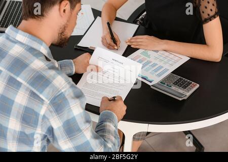 Couple signing a loan contract in bank Stock Photo