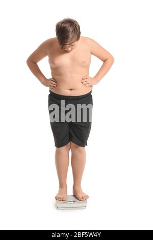 Overweight boy standing on scales against white background Stock Photo ...