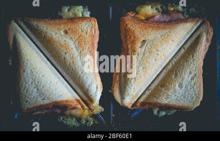 Toasts with ham and cheese toasted into triangles on toaster Stock Photo