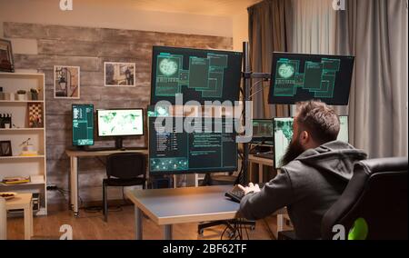 Bearded hacker in a room full of computers to attack government security. Stock Photo