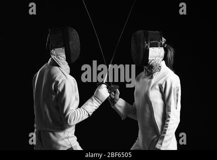 Young fencers on dark background Stock Photo