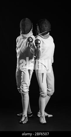 Young fencers on dark background Stock Photo