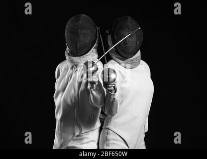 Young fencers on dark background Stock Photo