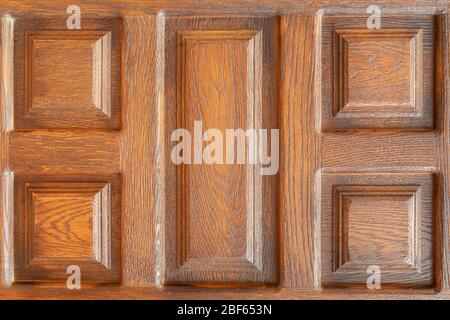 Close-up on a wooden door showing repetitive patterns due to precise craftsmanship. The patterns are square and rectangular Stock Photo