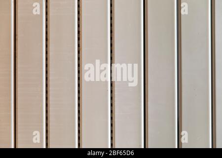 Close-up on a radiator composed of horizontal heating panels. They are white and worn and have interstices made up of small holes Stock Photo