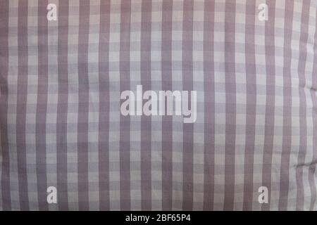 Close-up on the fabric of a pillow. it is made up of a repetitive geometric pattern of small tiles in different shades of gray. Stock Photo