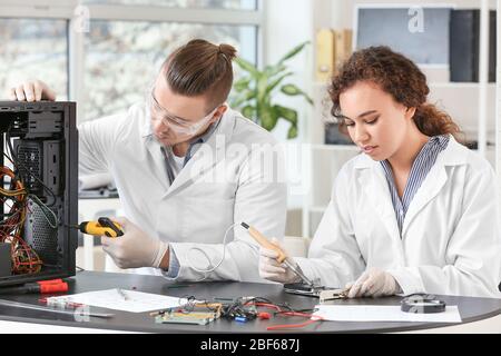 Electronic technicians working in service center Stock Photo