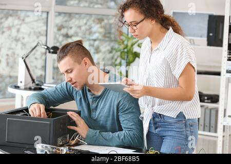 Electronic technicians working in service center Stock Photo