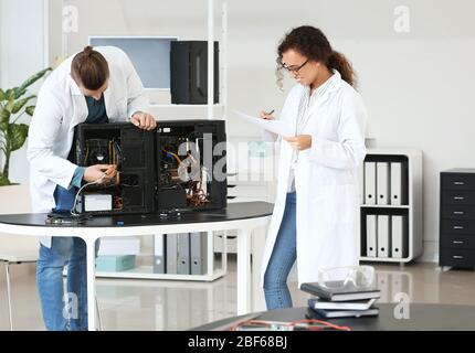 Electronic technicians working in service center Stock Photo