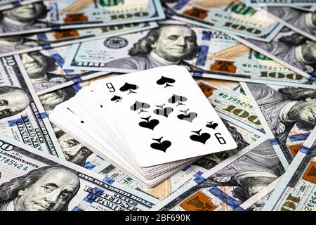 Hundred dollar bills, a deck of playing cards and a black ...