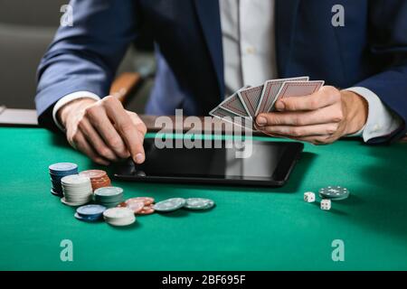 Man with tablet computer playing poker online, closeup Stock Photo