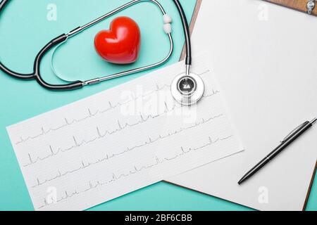 Stethoscope, heart, clipboard and cardiogram on color background Stock Photo