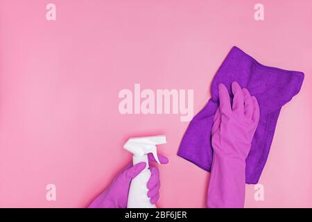 Hand in a rubber yellow glove holds pink bottle of liquid bleach on a white background. cleaning Stock Photo