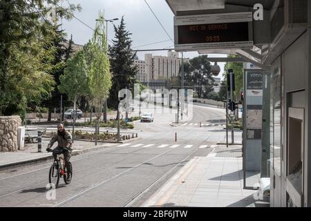 Jerusalem, Israel. 17th Apr, 2020. A man rides a bicycle on the tram tracks while public transportation is suspended under government imposed Coronavirus restrictions. Credit: Nir Alon/Alamy Live News Stock Photo