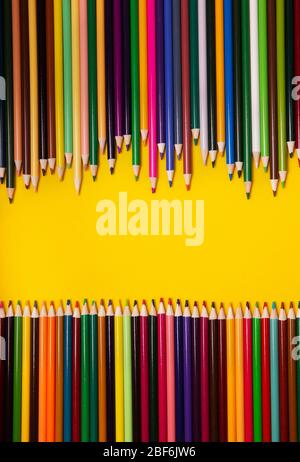 Colorful multicolor pencils on yellow background. Top view, copy space Stock Photo