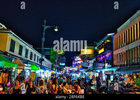 Tourists and backpackers walk by Khao San Road in Bangkok, Thailand. Khao San Road is a famous low budget hotels and guesthouses area in Bangkok. Stock Photo