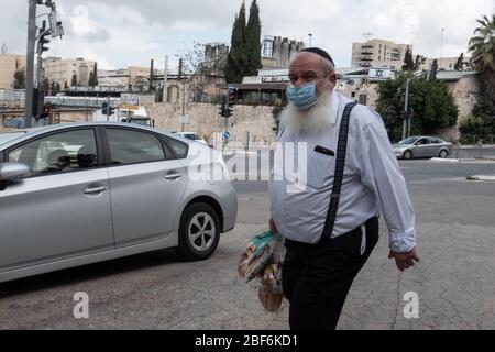 Jerusalem, Israel. 17th Apr, 2020. A Jewish religious man walks home after purchasing fresh bread in preparation for the Sabbath in the Kiryat Moshe neighborhood, one of 17 predominantly Jewish religious neighborhoods in Jerusalem, with increased coronavirus infections. The number of confirmed COVID-19 cases in Israel rises to 12,855 with 148 deaths. Credit: Nir Alon/Alamy Live News Stock Photo